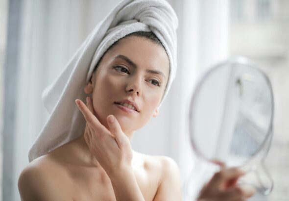 A serene and elegant woman enjoys a skincare ritual, enhancing her natural beauty in the comfort of her home.
